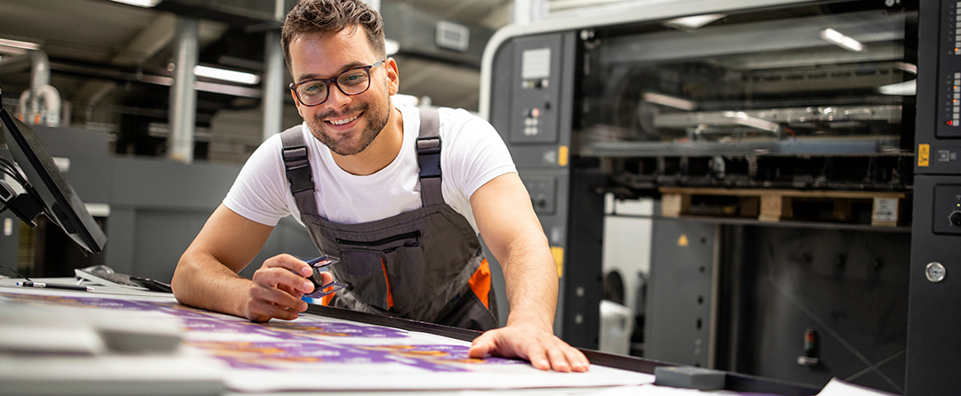 man smiling over a table with catalogues